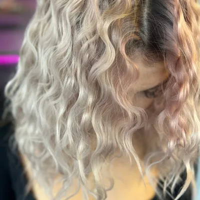Lockiges Haar in hellem Silberblond mit dunklem Ansatz