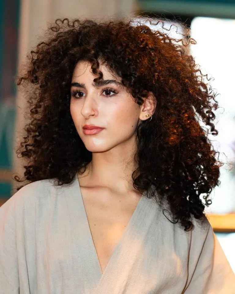 Frau mit langen, voluminösen dunklen Locken